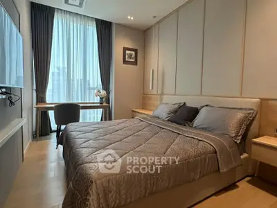 Luxurious bedroom with elegant decor and large window offering natural light.