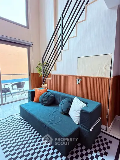 Stylish loft living room with modern staircase and cozy seating area.