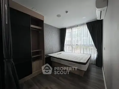 Modern bedroom with sleek design, featuring a large window and stylish furnishings.