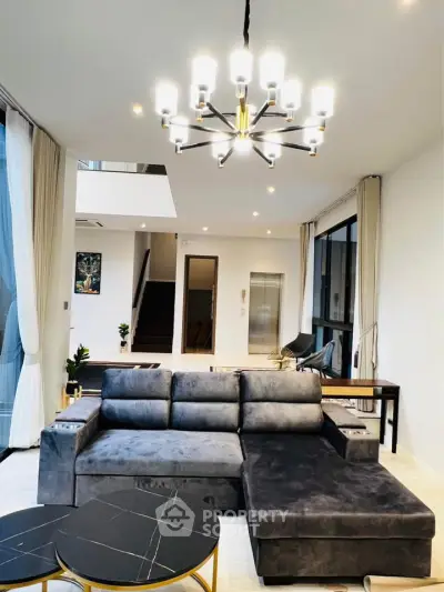 Luxurious modern living room with plush gray sofa and elegant chandelier