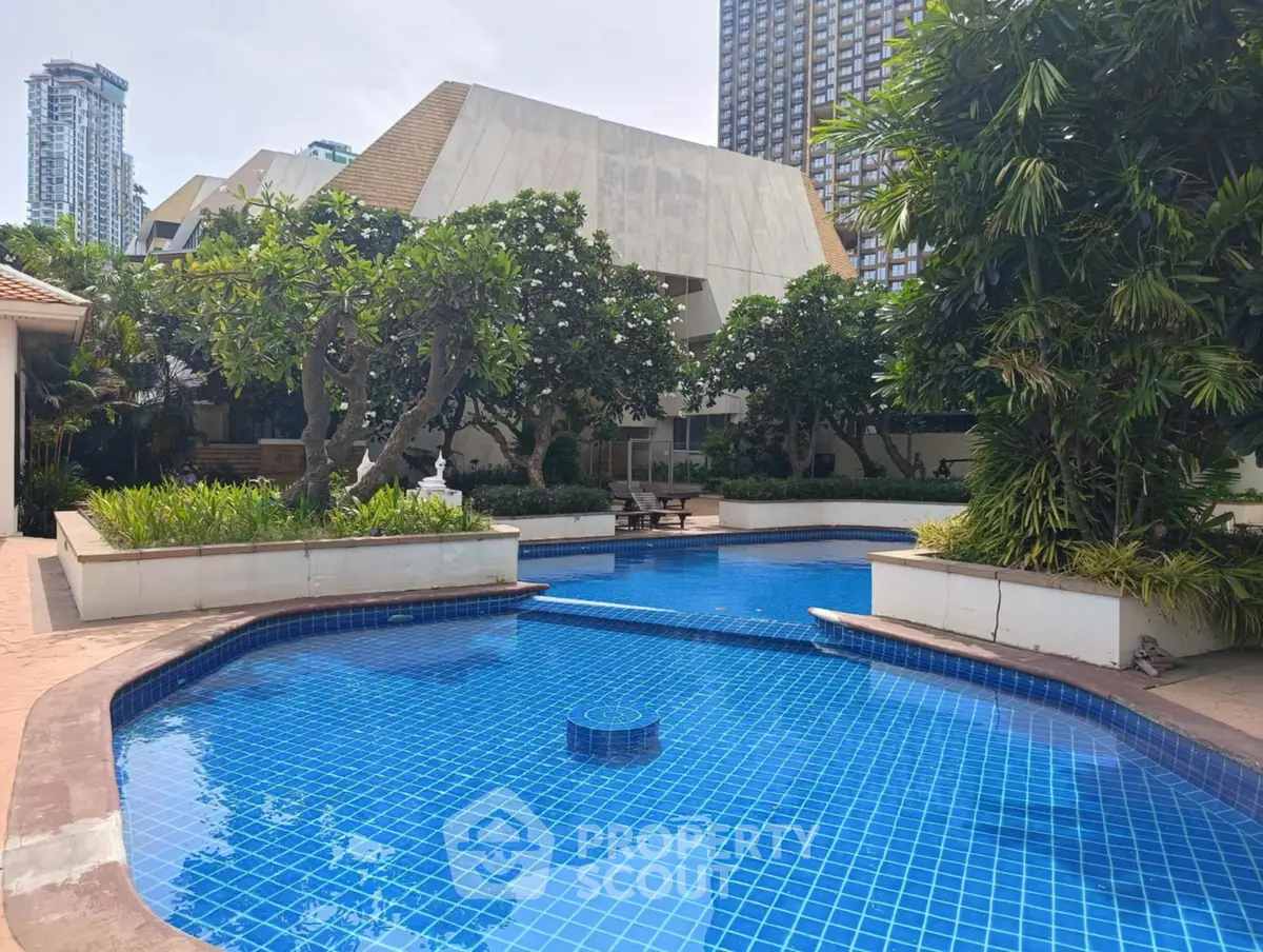 Luxurious residential pool surrounded by lush greenery and modern architecture.