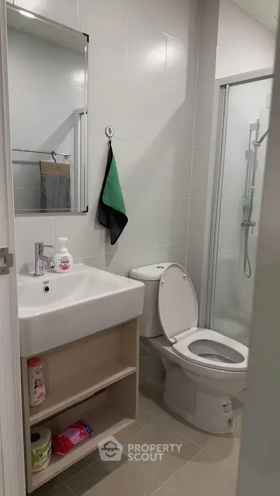 Modern bathroom with sleek fixtures and shower enclosure in a contemporary apartment.