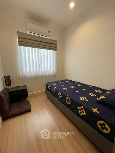 Cozy bedroom with single bed and air conditioning in modern apartment.