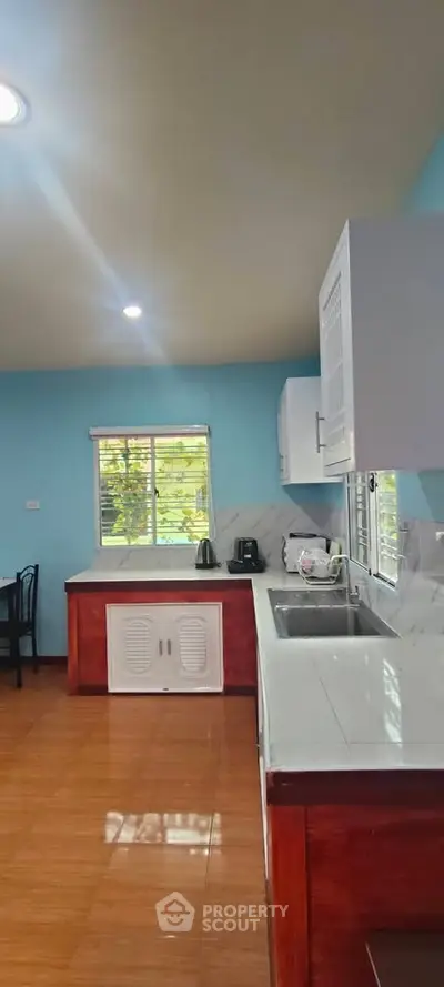 Spacious kitchen with modern cabinetry and large windows for natural light.