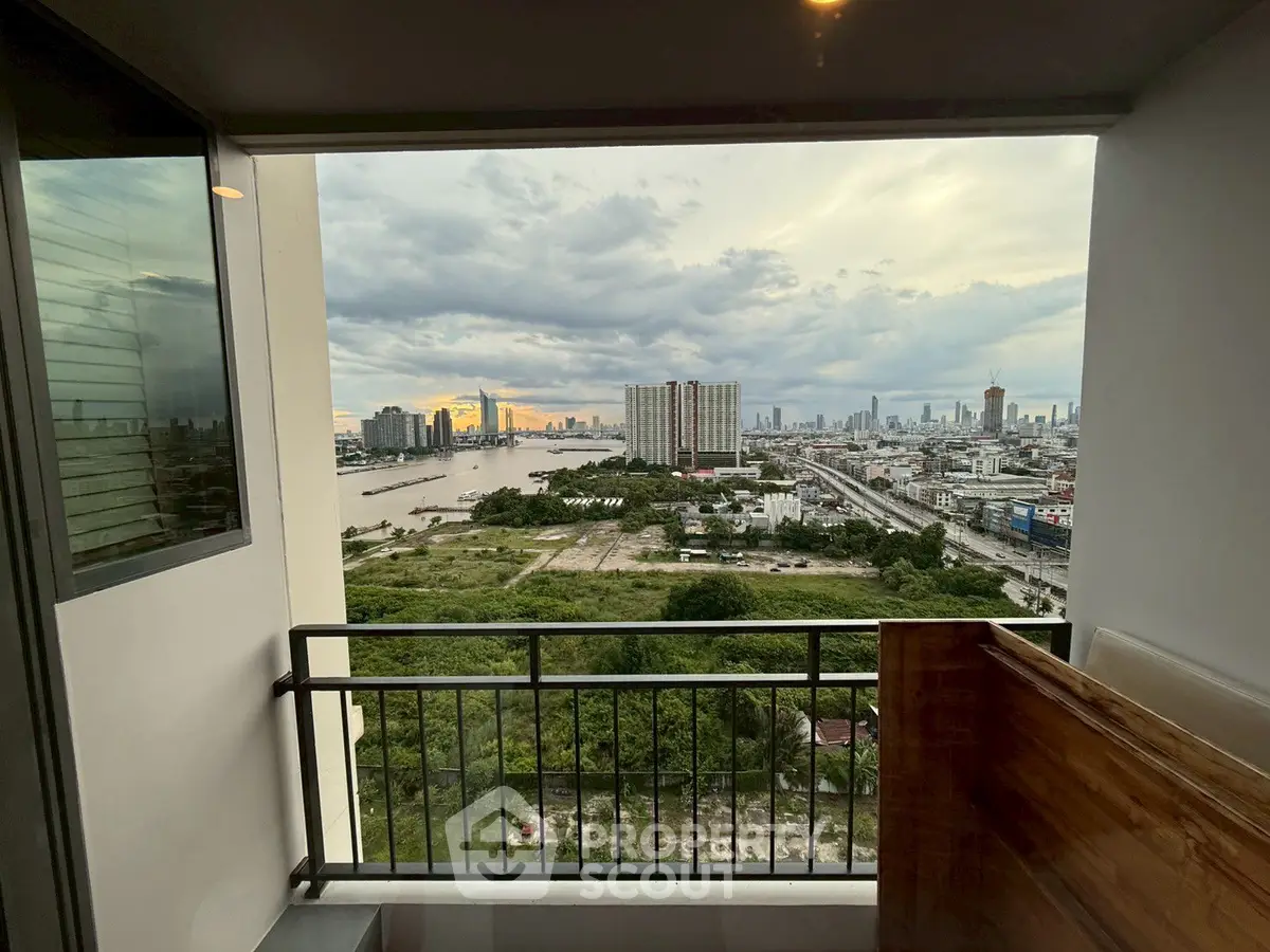 Stunning cityscape view from a high-rise balcony overlooking a river and skyline.