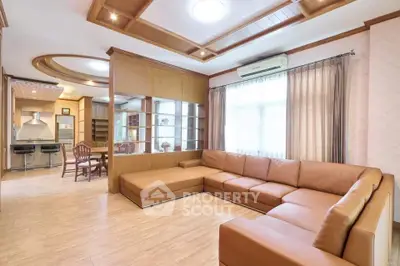 Spacious living room with modern open kitchen and elegant wooden accents.