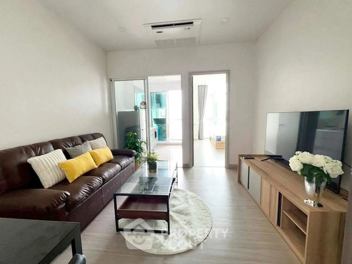 Modern living room with sleek furniture and natural light, perfect for relaxation and entertainment.
