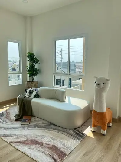 Bright living room with modern sofa, large windows, and playful llama decor.