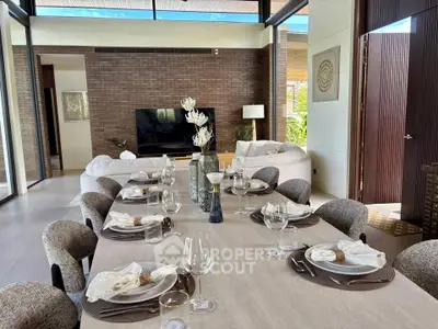 Luxurious open-plan living and dining area with elegant decor and large windows.