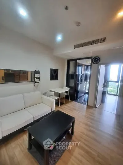 Modern living room with sleek furniture and wooden flooring in a stylish apartment.