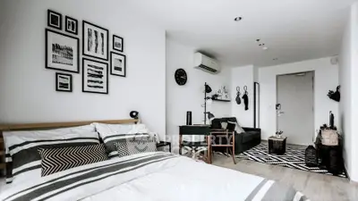 Modern bedroom with stylish decor and cozy seating area in a chic apartment.