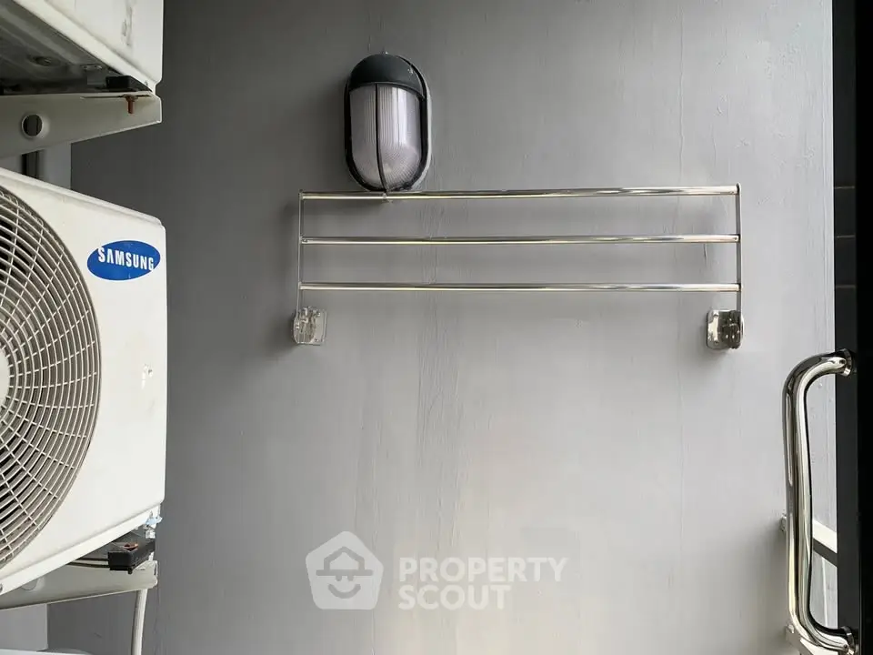 Outdoor area with air conditioning unit and wall-mounted light fixture, ideal for modern living spaces.