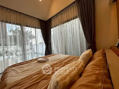 Luxurious bedroom with large windows and elegant curtains, offering a serene and cozy atmosphere.