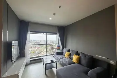 Modern living room with city view, stylish gray sofa and large window.