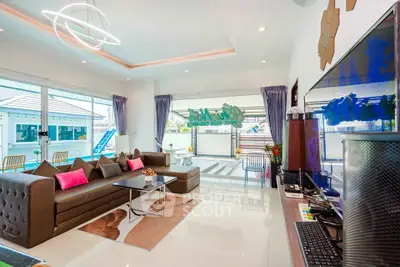 Spacious modern living room with stylish decor and large windows opening to a balcony.