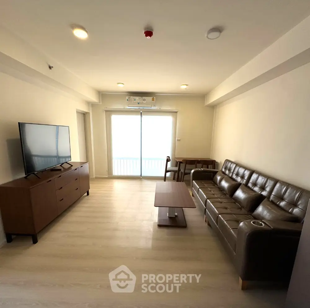 Modern living room with sleek furniture and large TV, perfect for relaxation.