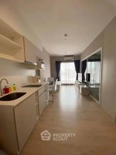 Modern open-layout kitchen and living area with natural light and sleek design.