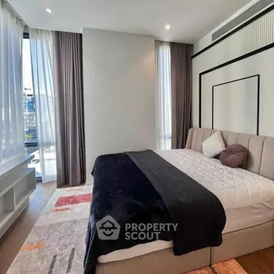 Luxurious modern bedroom with large windows and stylish decor in a high-rise apartment.