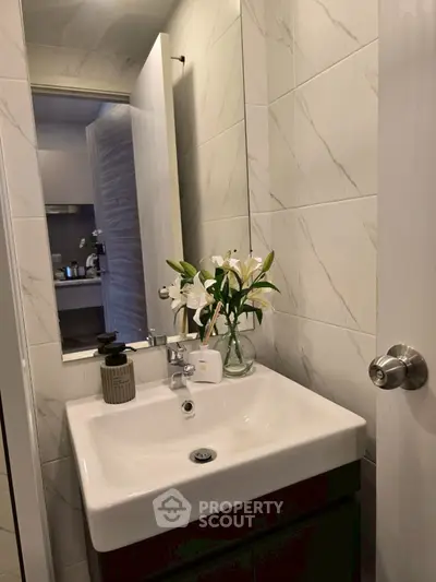 Modern bathroom with sleek sink and elegant floral arrangement