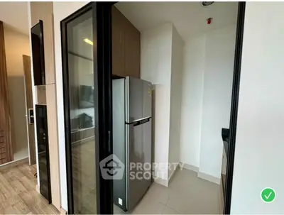Modern kitchen with sleek refrigerator and glass door entry