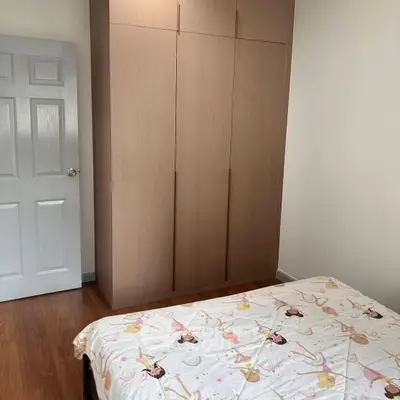 Cozy bedroom with wooden wardrobe and charming bedspread