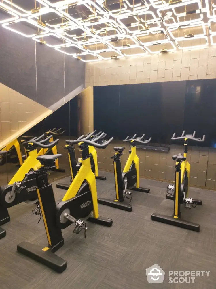 Modern gym with stylish lighting and yellow exercise bikes