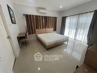 Spacious bedroom with natural light and modern furnishings