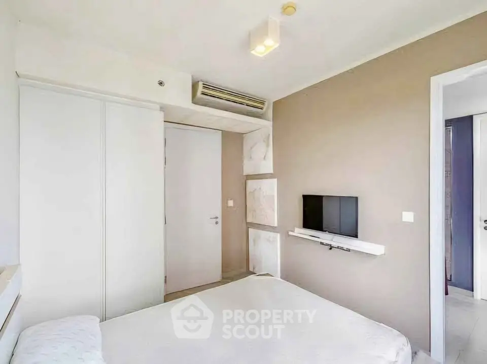 Modern bedroom with minimalist design and wall-mounted TV