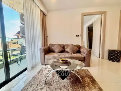 Modern living room with glass coffee table and cozy sofa, featuring a balcony view.