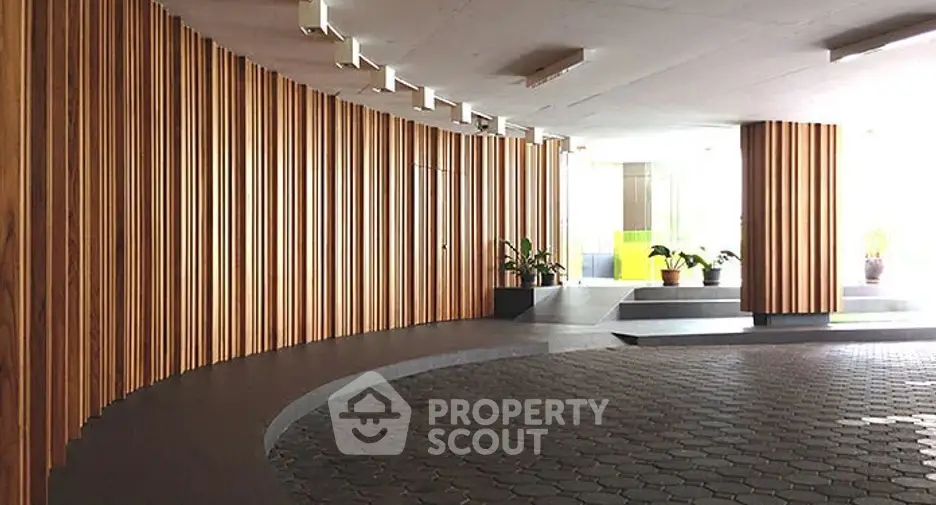 Modern building entrance with stylish wood paneling and potted plants