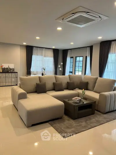 Spacious modern living room with elegant sectional sofa and large windows