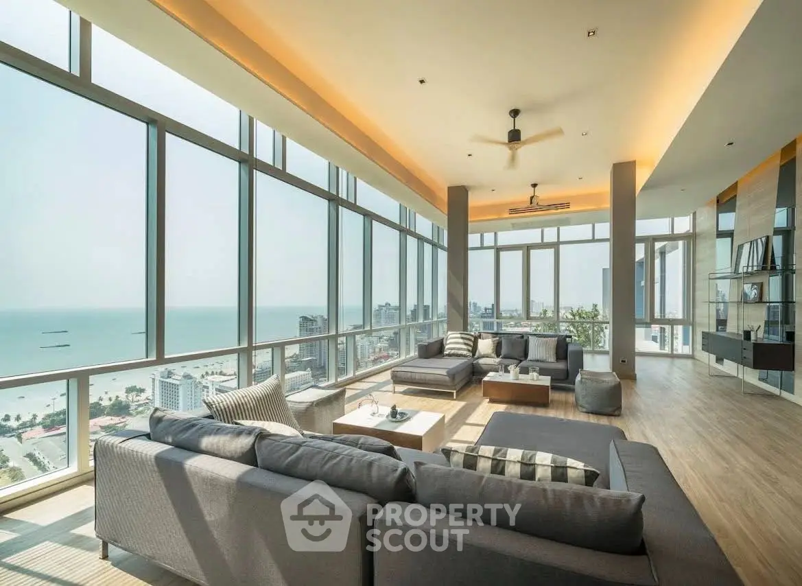 Luxurious corner unit living room with panoramic ocean views and modern furnishings.