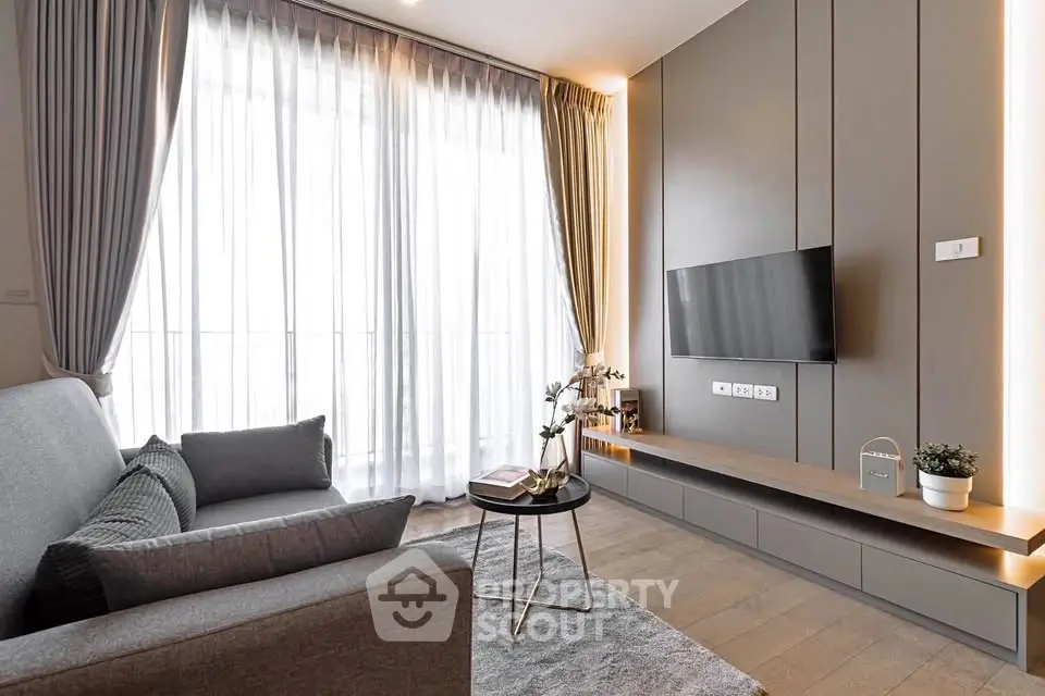 Modern living room with sleek design, large window, and stylish furniture in a contemporary apartment.