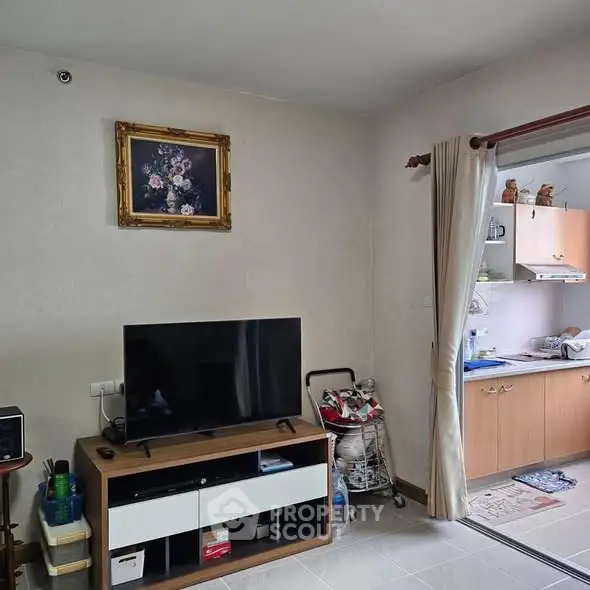 Cozy living room with TV and open kitchen view, perfect for modern living.