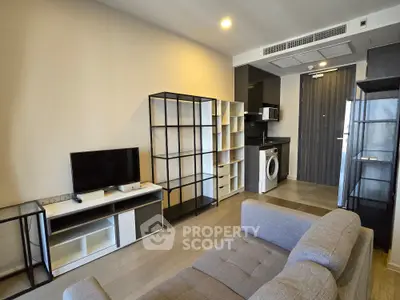 Modern living room with sleek furniture and integrated kitchen appliances in a stylish apartment.