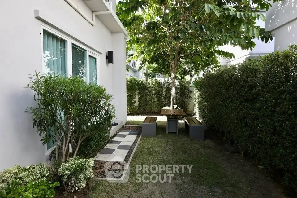 Charming garden area with lush greenery and outdoor seating, perfect for relaxation.