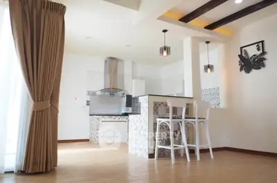 Spacious open-plan kitchen with modern design and stylish bar seating in a bright, airy room.