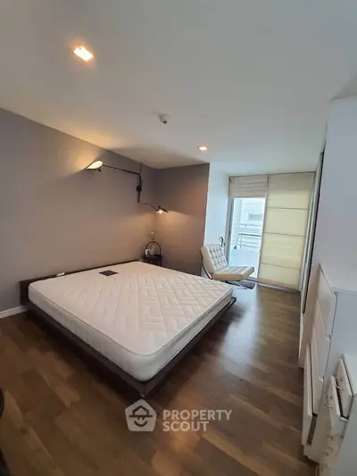 Modern bedroom with minimalist design and large window for natural light.