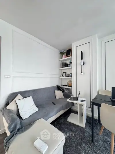Modern living room with cozy sofa, sleek decor, and workspace setup.