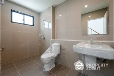 Spacious modern bathroom with sleek fixtures and large window for natural light.