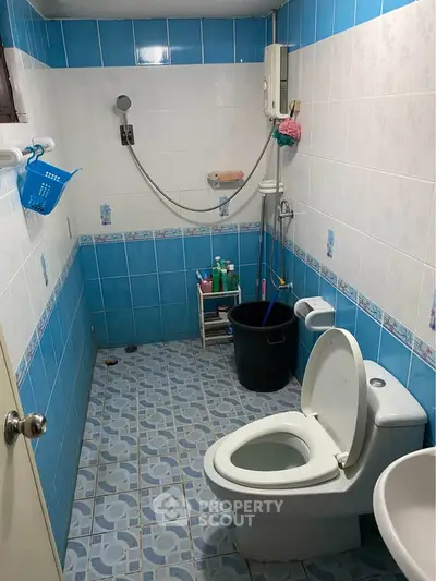 Spacious bathroom with blue and white tiles, featuring modern fixtures and ample storage space.