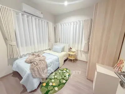 Cozy bedroom with modern decor, featuring a single bed, stylish curtains, and a vibrant floral rug.