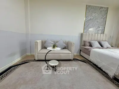 Elegant bedroom with plush bed and cozy sofa, perfect for relaxation.