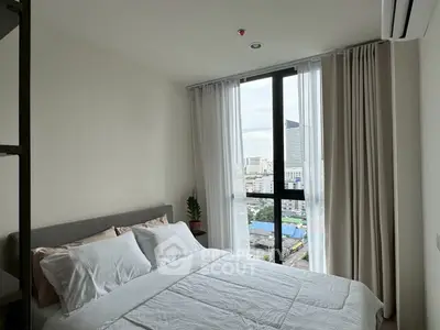 Cozy bedroom with city view and modern decor, perfect for urban living.