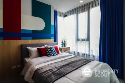 Modern bedroom with colorful accent wall and large windows