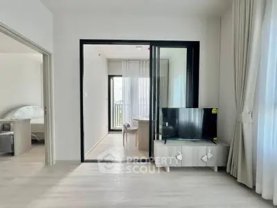 Modern living room with sleek TV stand and large windows offering natural light.