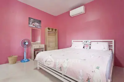 Charming bedroom with pink walls, cozy bed, and air conditioning for comfort.