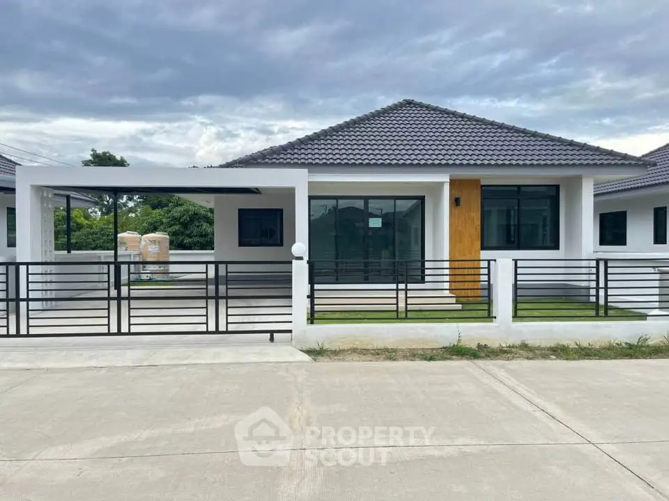 Modern single-story house with sleek design and spacious driveway in a serene neighborhood.