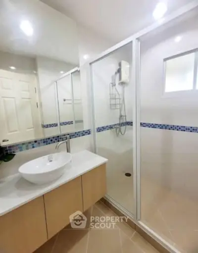 Modern bathroom with glass shower and stylish vanity in contemporary home.