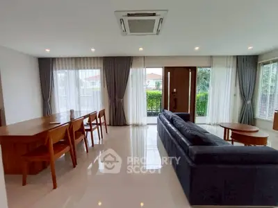Spacious modern living room with elegant furniture and large windows offering natural light.